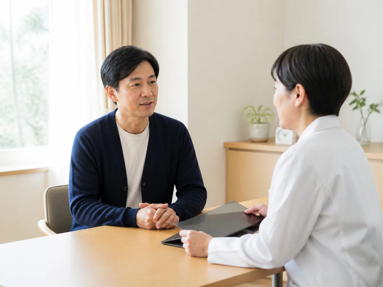 テーブルを挟んで話す中年の男性と女性のイメージ